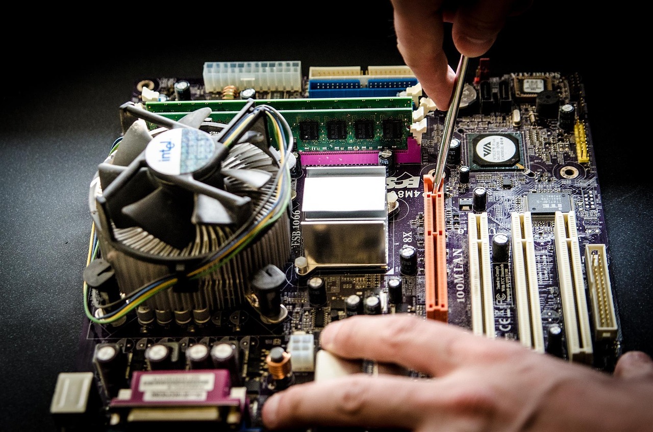 Technician's hand working on a PC motherboard